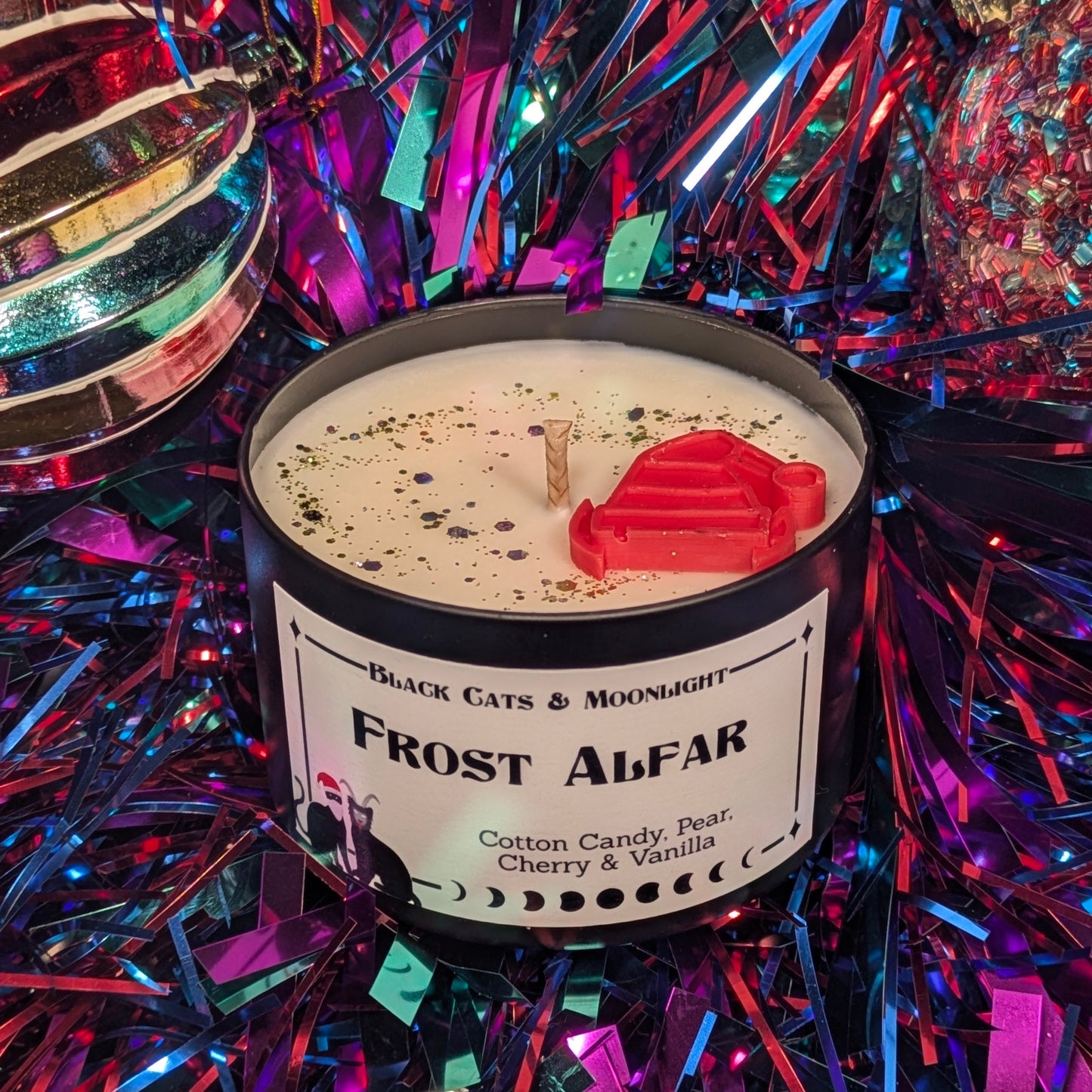 Candle labeled 'Frost Alfar' surrounded by colorful tinsel
