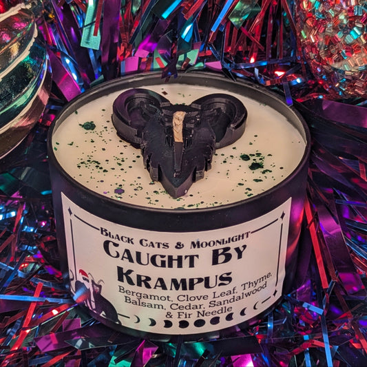 Candle with a Krampus decoration on top, surrounded by colorful tinsel